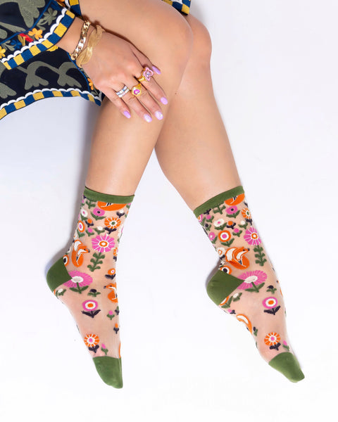 Person wearing floral-patterned socks with a white background