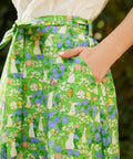 Close-up of The Garden Stroll Skirt in Hide & Squeak featuring illustrated mice, butterflies, wildflowers, side seam pockets, and a removable self-tie sash.