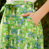 Close-up of The Garden Stroll Skirt in Hide & Squeak featuring illustrated mice, butterflies, wildflowers, side seam pockets, and a removable self-tie sash.