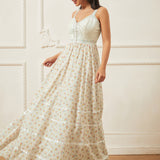 Woman wearing a long, light-colored dress with a subtle pattern against a white wall.