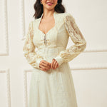 Woman wearing a long-sleeve lace dress against a white background