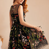 Back view of a black embroidered floral dress featuring an illusion mesh back and fit-and-flare silhouette.
