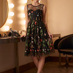 Woman wearing an elegant embroidered floral tulle dress styled for a special occasion.