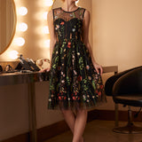 Woman wearing an elegant embroidered floral tulle dress styled for a special occasion.