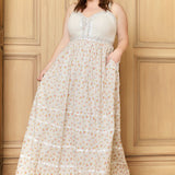 A woman modeling a sleeveless, tiered, floral maxi dress with a corset-style bodice.
