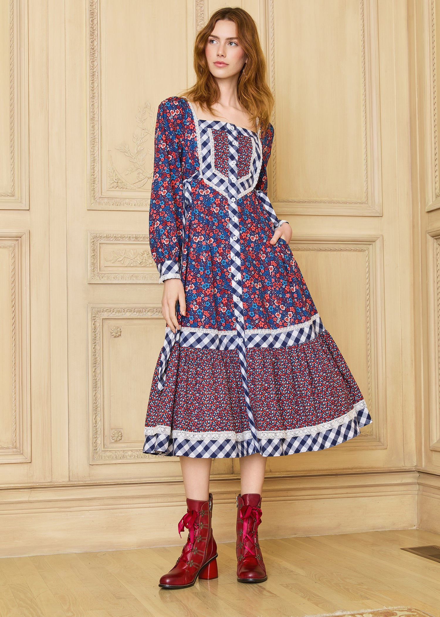 A model wearing a GUNNE SAX for ModCloth Veronica Midi Dress with a floral pattern and long sleeves, paired with red boots.