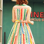 Back view of the Rainbow Carousel sleeveless fit-and-flare dress with rainbow stripe and polka dot print.