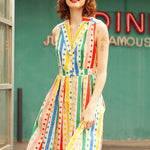 Front view of the Rainbow Carousel fit-and-flare dress featuring rainbow stripes, polka dots, and a button-front design.