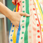 Close-up of side pocket on the Rainbow Carousel cotton dress with colorful striped and polka dot print.
