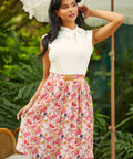 Model wearing a high-waisted A-line skirt with colorful dragon fruit print and matching belt, front view