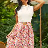 Model wearing a high-waisted A-line skirt with colorful dragon fruit print and matching belt, front view