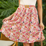 Woman wearing a pink crinkle rayon skirt with a white top in a garden setting