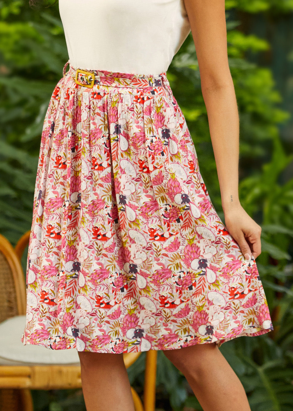 Person wearing a vintage inspired fruit print skirt with a blurred green background