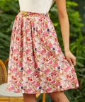 Person wearing a vintage inspired fruit print skirt with a blurred green background