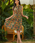 Woman in a floral dress standing outdoors with greenery in the background