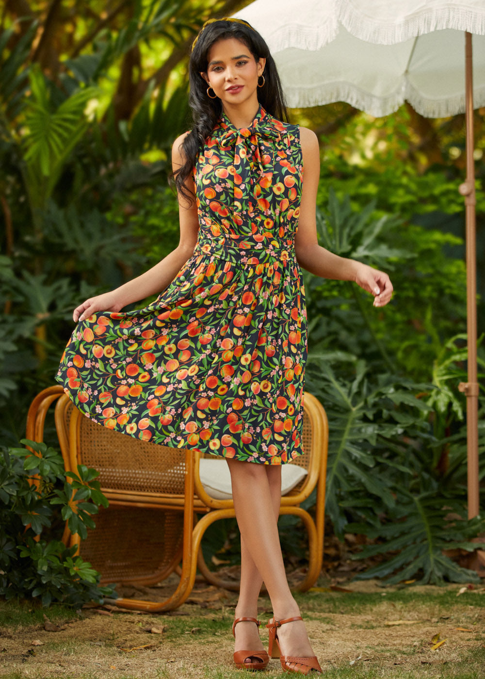 Woman in a floral dress standing outdoors with greenery in the background