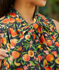 Close-up of adjustable bow tie neckline on peach floral dress