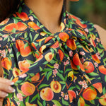 Close-up of adjustable bow tie neckline on peach floral dress