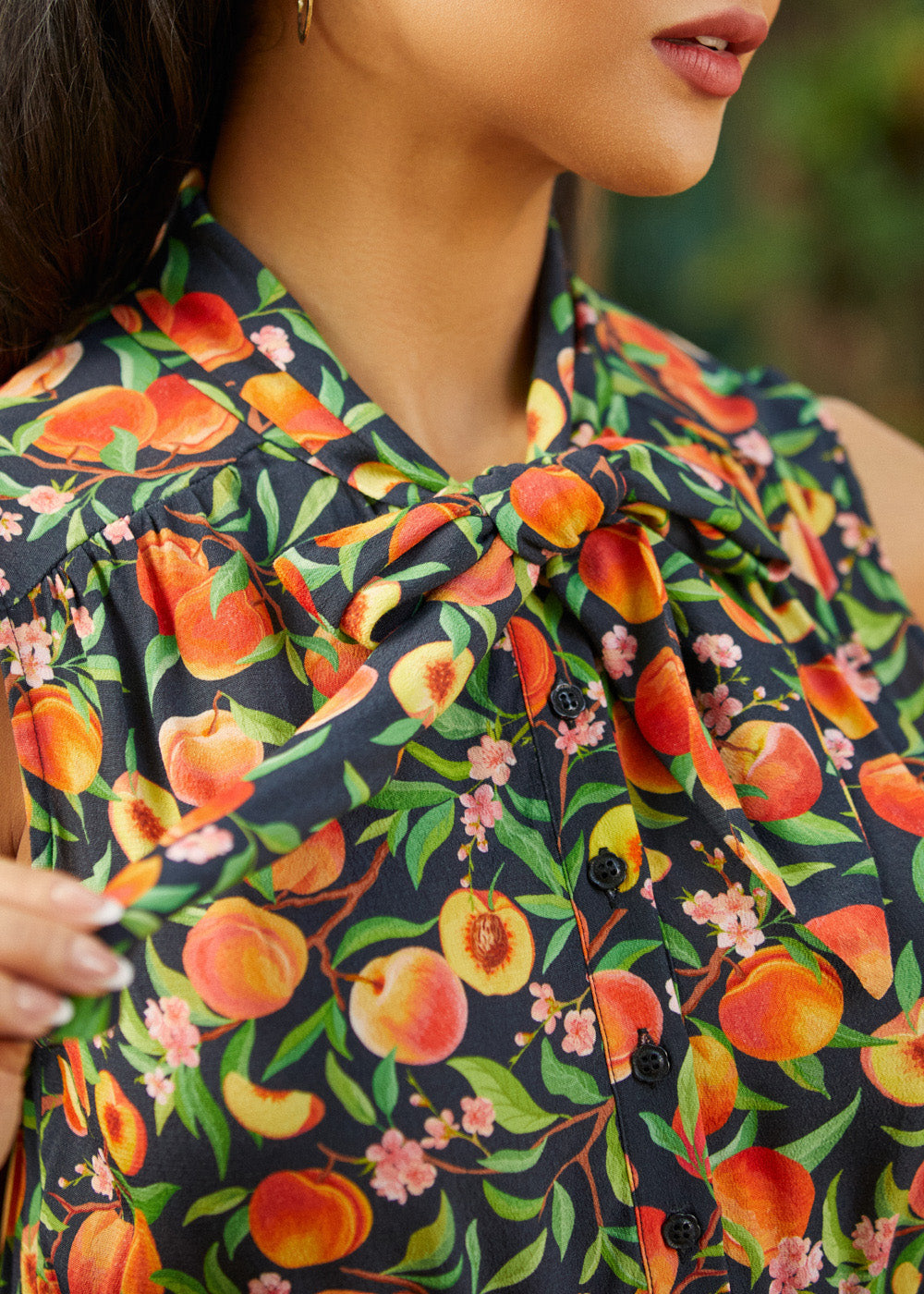 Close-up of adjustable bow tie neckline on peach floral dress