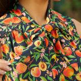 Close-up of adjustable bow tie neckline on peach floral dress