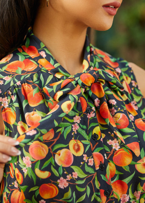 Close-up of adjustable bow tie neckline on peach floral dress
