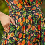 Detail of waistband and gathered skirt with side pockets on dress with vibrant fruit print