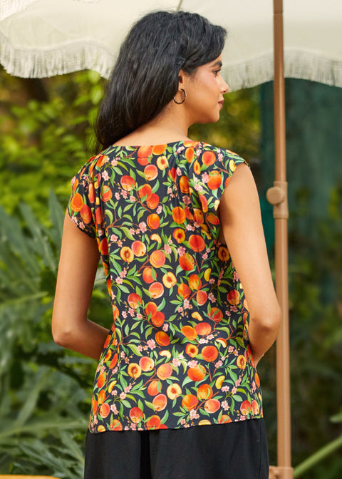 Back view of peach print blouse with relaxed fit and short sleeves