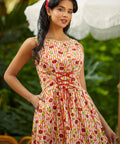 Woman wearing a colorful patterned dress with a blurred outdoor background