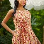 Woman wearing a colorful patterned dress with a blurred outdoor background