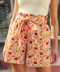 Person wearing a patterned pair of shorts with a bow at the waist