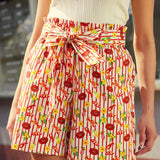 Person wearing a patterned pair of shorts with a bow at the waist