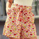 Person wearing shorts with a lobster, lemon, and striped print on cotton fabric 