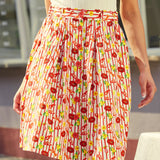 Model wearing button front skirt with red buttons and flared shape