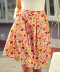 pleated skirt on woman, fabric with lobster, citrus, and striped print