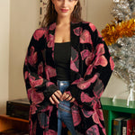 Woman wearing a black and pink flowy butterfly kimono cardigan