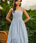 Vintage-inspired fit and flare sundress with ruched bodice, adjustable straps, and floral gingham print, front view