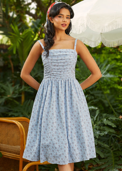 Vintage-inspired fit and flare sundress with ruched bodice, adjustable straps, and floral gingham print, front view