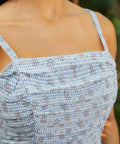 Close-up of ruched bodice on floral gingham sundress with adjustable straps and textured detailing