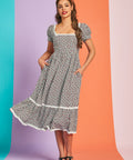 Woman twirling in vintage-inspired strawberry gingham midi dress with pockets