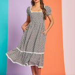Woman twirling in vintage-inspired strawberry gingham midi dress with pockets