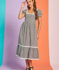 Woman wearing black and white gingham strawberry print midi dress with puff sleeves and square neckline