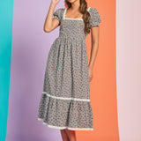 Woman wearing black and white gingham strawberry print midi dress with puff sleeves and square neckline