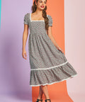 Woman wearing strawberry print puff sleeve midi dress with tiered skirt