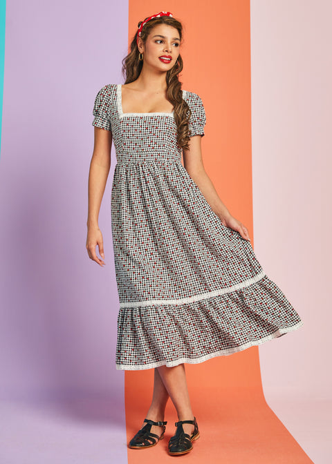 Woman wearing strawberry print puff sleeve midi dress with tiered skirt