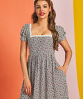Woman wearing vintage-inspired strawberry gingham fit and flare midi dress with pockets
