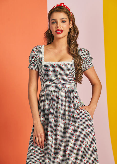 Woman wearing vintage-inspired strawberry gingham fit and flare midi dress with pockets