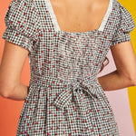 Close-up of lace-trimmed square neckline on strawberry gingham midi dress