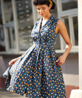 Woman twirling in a sleeveless fit-and-flare dress with playful chicken print.