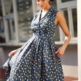 Woman twirling in a sleeveless fit-and-flare dress with playful chicken print.
