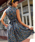 Back view of a farmyard chicken print dress with self-tie sash and novelty farmyard print.
